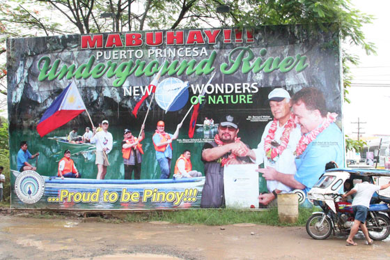 Poster on Palawan Island, the Philippines, featuring Bernard Weber, Founder-President of New7Wonders, Mayor Edward Hagedorn of Puerto Princesa City and Jean-Paul de la Fuente, New7Wonders Director. 