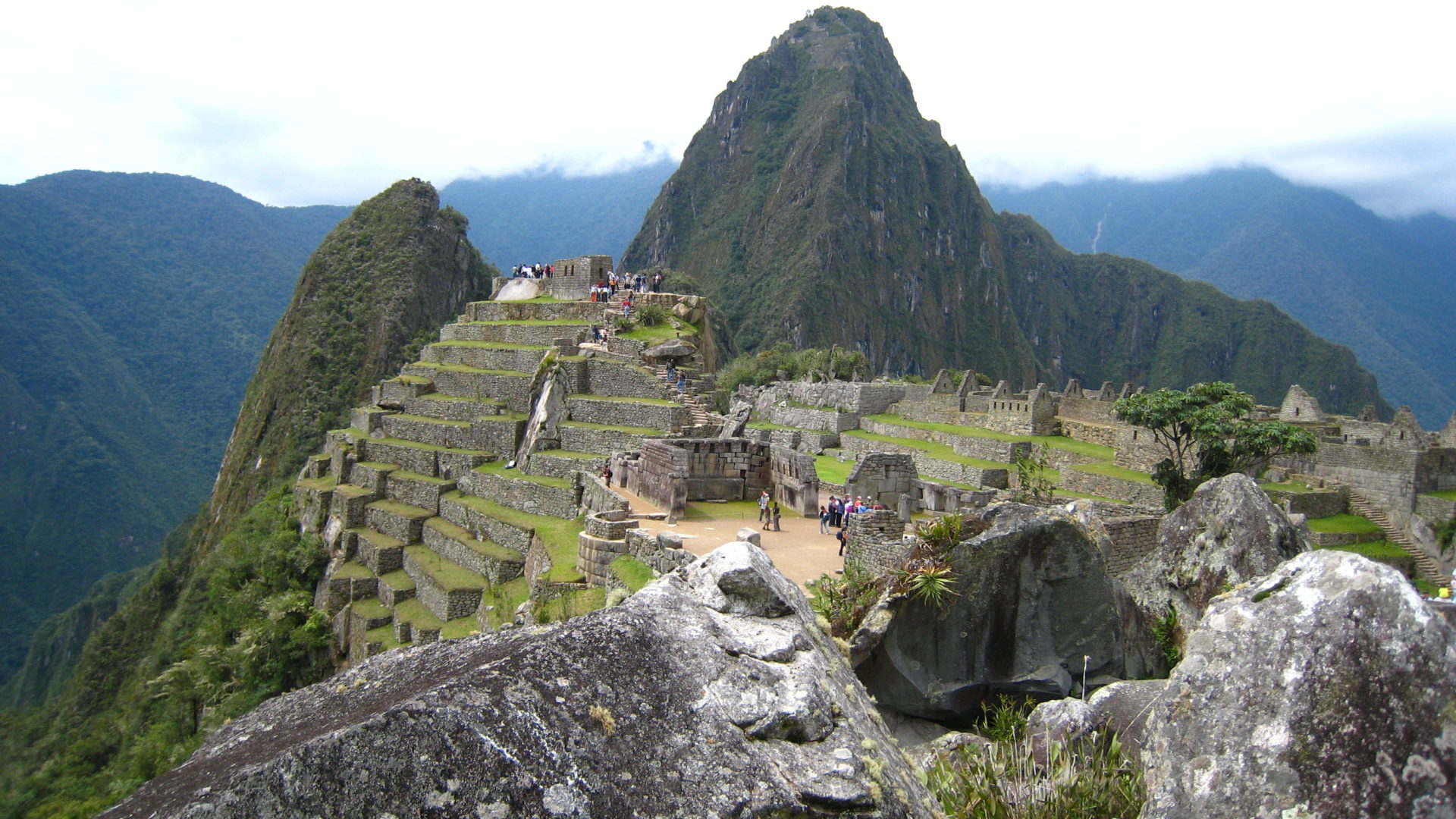 View of a section Machu Picchu, perched the top of the mountainside on very steep terrain.